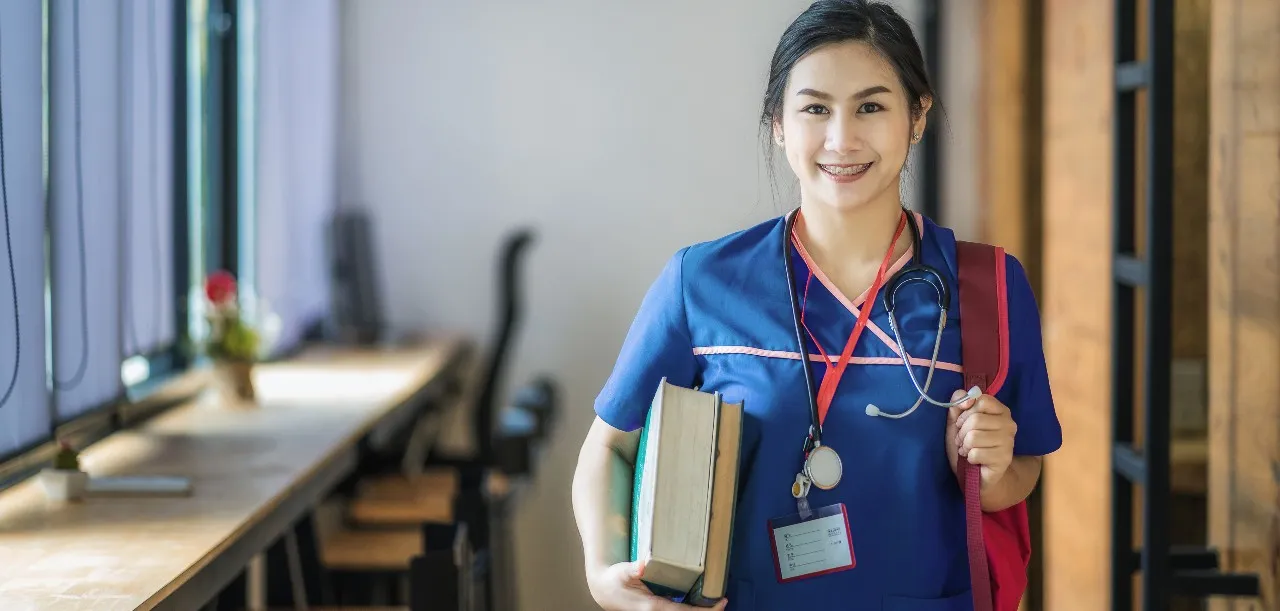 young nursing student holding books and backpack